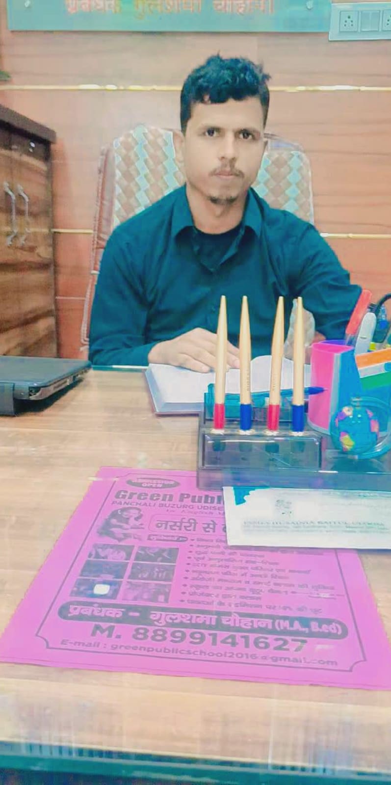 Portrait of Principal Ahsan Sir seated in the school office.